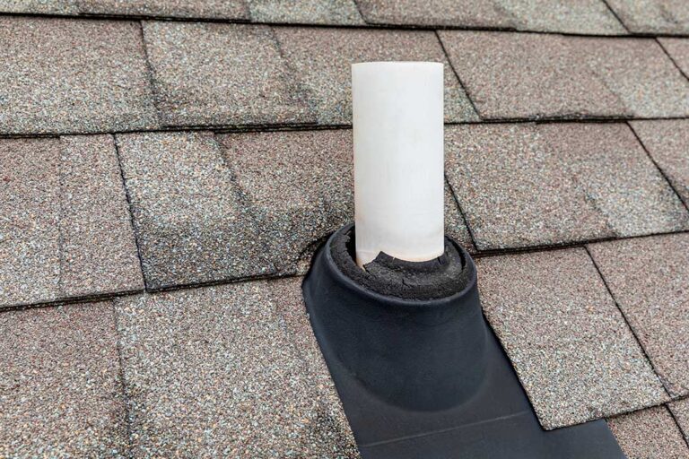 Homeowner inspecting a roof from the ground with binoculars while a secured ladder rests nearby. KEYWORDS: ["homeowner roof safety inspection", "ladder safety near house", "winter roof hazards"]
