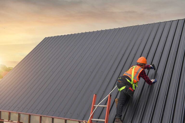 Homeowner reviewing roof warranty papers beside a folder of inspection records and roof photographs.